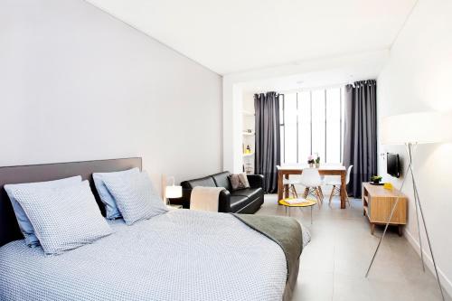 - une chambre avec un lit et un salon dans l'établissement Studios de Charme à Montmartre, à Paris