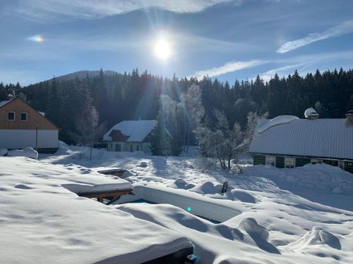 a snow covered yard with houses and buildings at Chalet Schäfer s vyhřívaným bazénem se slanou vodou in Harrachov