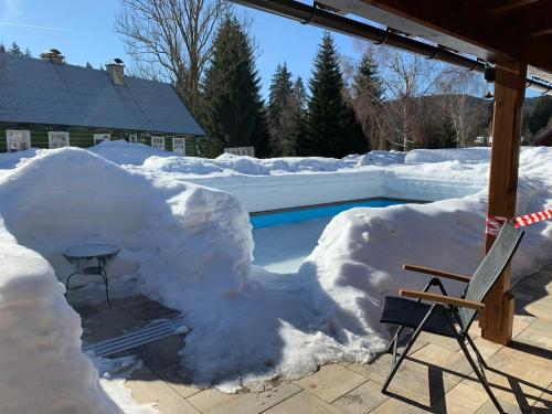 a pile of snow next to a swimming pool at Chalet Schäfer s vyhřívaným bazénem se slanou vodou in Harrachov