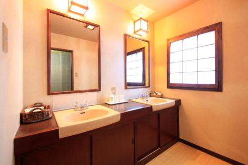 a bathroom with two sinks and two mirrors at TheMana Village in Tosashimizu