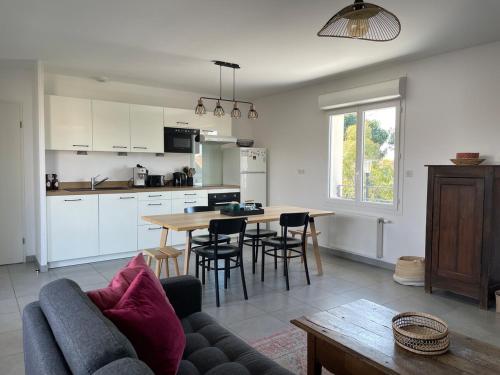 une cuisine et un salon avec un canapé et une table dans l'établissement Appartement lumineux 5 personnes, à La Teste-de-Buch