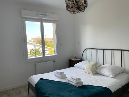 une chambre avec un lit avec deux serviettes dessus dans l'établissement Appartement lumineux 5 personnes, à La Teste-de-Buch