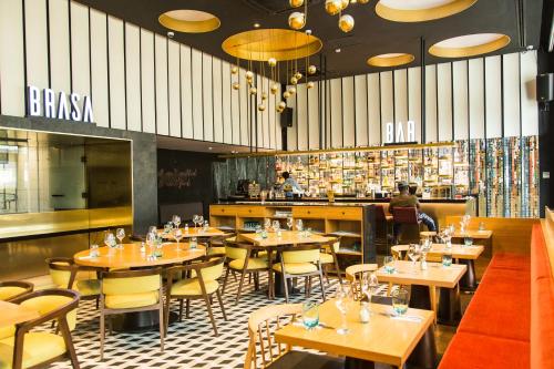 a restaurant with tables and chairs and a bar at Accra Luxury Apartments at The Edge in Accra