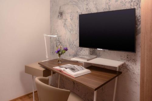 a desk with a computer and a monitor on it at Avani Palazzo Moscova Milan Hotel in Milan