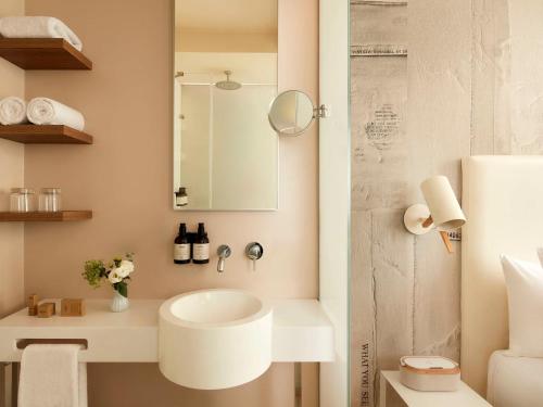 a white bathroom with a sink and a shower at Avani Palazzo Moscova Milan Hotel in Milan