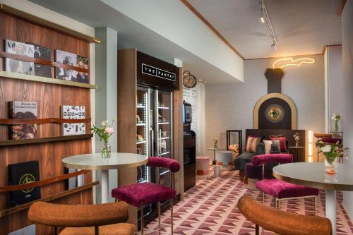 a restaurant with two tables and purple chairs at Avani Palazzo Moscova Milan Hotel in Milan