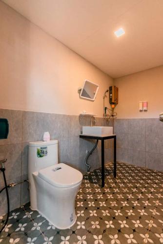 a bathroom with a toilet and a sink at สวนส้มลุงเก๊าโฮมสเตย์แม่แตง in Ban Mae Na