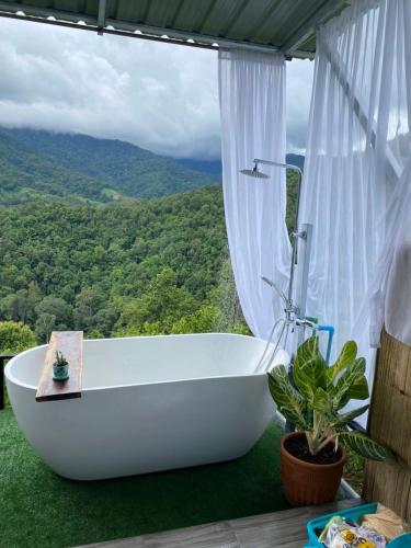 a bath tub in a bathroom with a view at สวนส้มลุงเก๊าโฮมสเตย์แม่แตง in Ban Mae Na