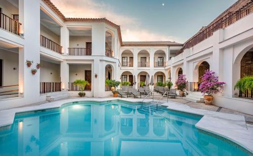 Una vista exterior de una mansión con piscina. en NH Collection Amistad Córdoba, en Córdoba