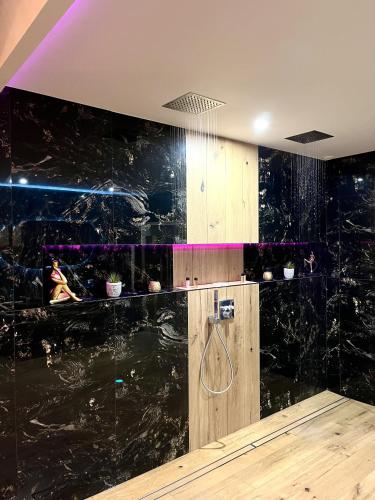 a black marble bathroom with a shower in it at L'Apogée in Noyal-Pontivy