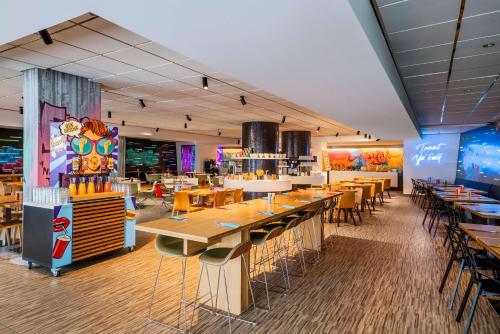 a dining room with tables and chairs and a restaurant at nhow Brussels Bloom in Brussels