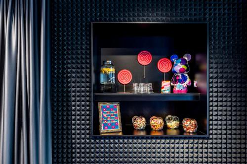 a black shelf with decorations on a wall at nhow Brussels Bloom in Brussels