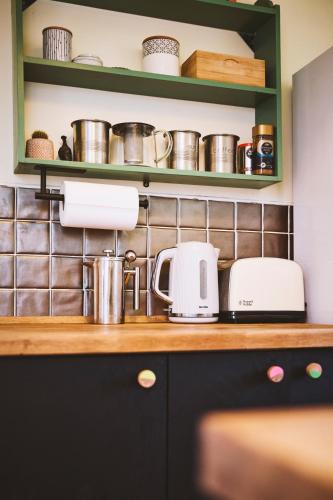 a kitchen counter with pots and pans on a shelf at Cosy home in Chapel Allerton Area - Peaceful Street, Free Parking in Leeds