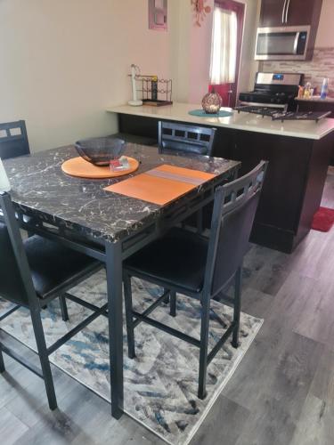 a dining room table with chairs and a counter at Silverbuttons in Rat Island