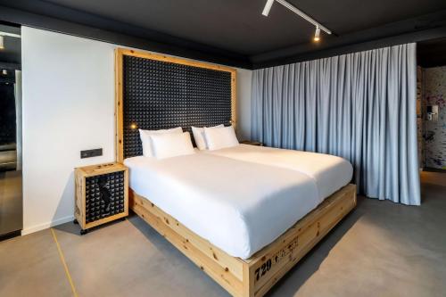 a bedroom with a large bed and a window at nhow Brussels Bloom in Brussels