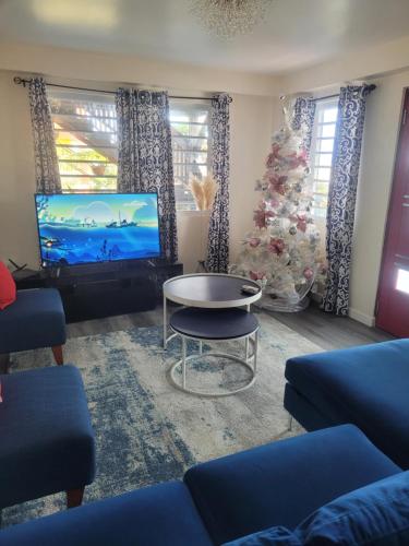 a living room with a christmas tree and a tv at Silverbuttons in Rat Island