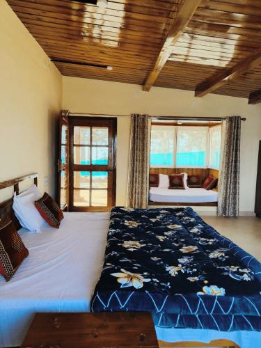 a bedroom with a large bed in a room with windows at Pinaceae Resort in Chakrāta