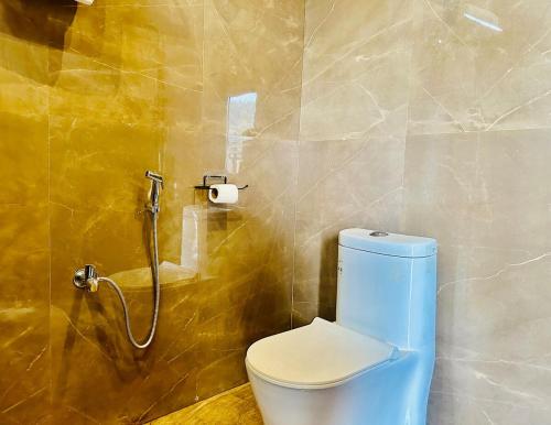 a bathroom with a blue toilet and a shower at The Luxe Villa by Vaaranya Group in Varanasi