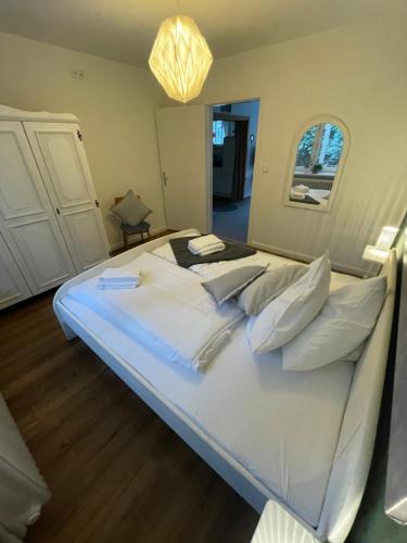 a large bed with white sheets and pillows at Haus Sonnenschein in Bispingen