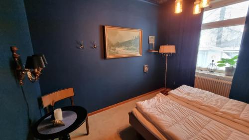 a bedroom with a bed and a table and a window at Piteå Vandrarhem in Piteå