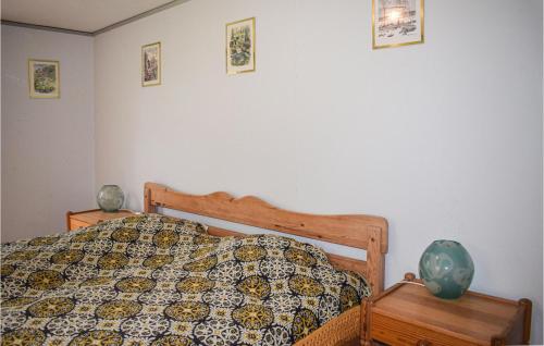 a bedroom with a bed with a comforter and pictures on the wall at Pet Friendly Home In Ryd With Kitchen in Ryd