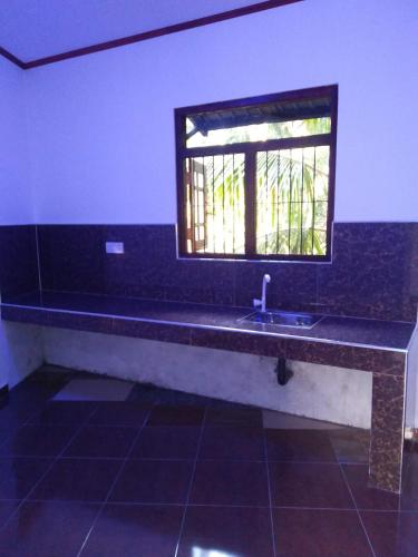 a bathroom with a sink and a window at Kelani Riverside Retreat in Kitulgala