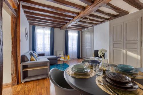 un salon avec une table et un canapé dans l'établissement Résidence royale T3, à Dreux