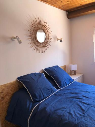 une chambre avec un lit bleu et un miroir dans l'établissement Villa Les Sablettes à 50m de la plage-Canet en Roussillon, à Canet