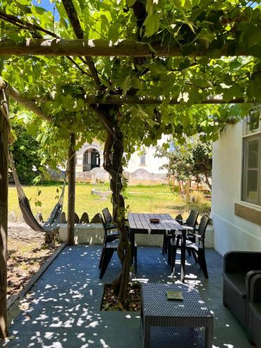 a wooden table and chairs under a pergola at Train Spot Guesthouse in Marvão