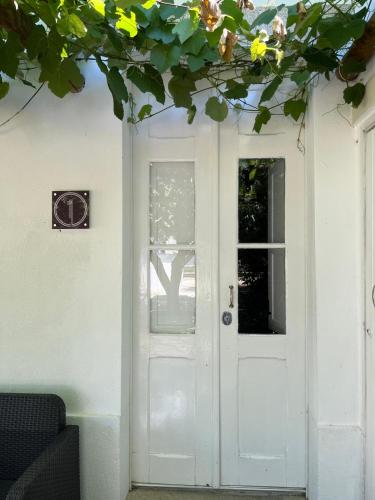 a white door with a window on a white house at Train Spot Guesthouse in Marvão