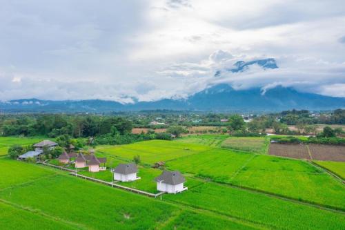 an aerial view of a farm with green fields and mountains at บ้านผ่อดอยกอยดาวพรีเมี่ยม in Ban Sop Nong