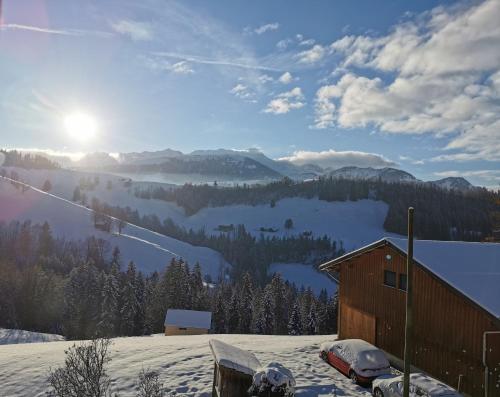 a house in the snow with a view of a mountain at Strickerhof in Hundwil