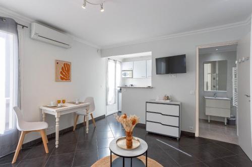 Cet appartement blanc comprend une table et une cuisine. dans l'établissement Rue Hoche by Halldis, à Cannes