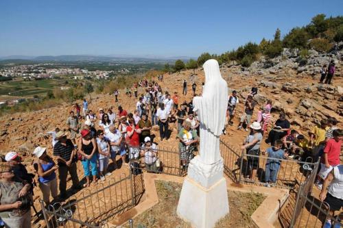 a crowd of people standing around a statue on a hill at Matea Apartment in Čitluk