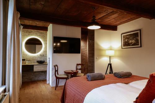 a bedroom with a bed and a desk in a room at Bed and Breakfast Basten Asbeck in Groenlo