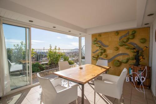 une salle à manger avec une table en bois et des chaises blanches dans l'établissement ROOF TERRACE OF 123m2 sea view double garage air conditioning, à Cannes