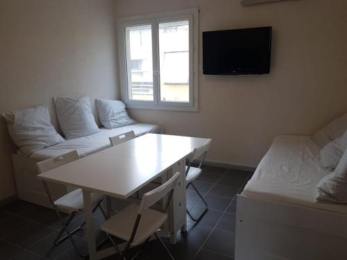 un salon avec une table et un canapé dans l'établissement Studio les pieds dans l'eau, au Grau-du-Roi