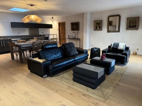 - un salon doté d'un mobilier en cuir noir et d'une table dans l'établissement casa di santa, à Aléria