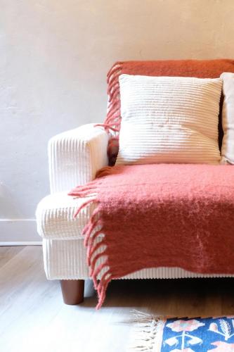a white chair with a red blanket on it at La Verrière - Chambre d'hôtes et gîte de charme in Poligny