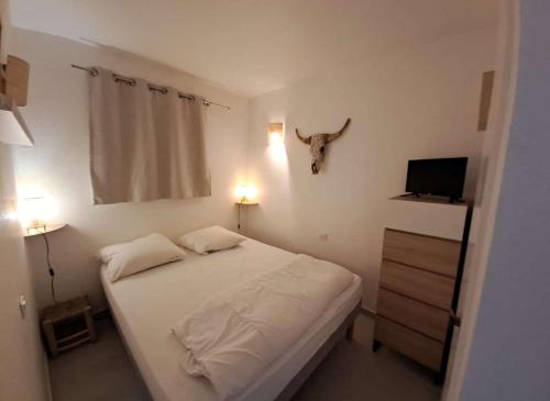 une petite chambre avec un lit et une télévision dans l'établissement GASARTI Superbe T2 climatisé avec belle terrasse proche de la plage, à Gassin