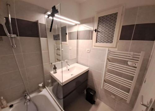 une salle de bain avec un lavabo, un miroir et une baignoire dans l'établissement GASARTI Superbe T2 climatisé avec belle terrasse proche de la plage, à Gassin