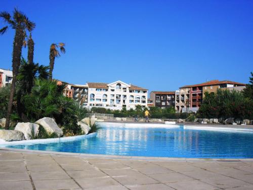 une grande piscine avec des bâtiments en arrière-plan dans l'établissement GASARTI Superbe T2 climatisé avec belle terrasse proche de la plage, à Gassin