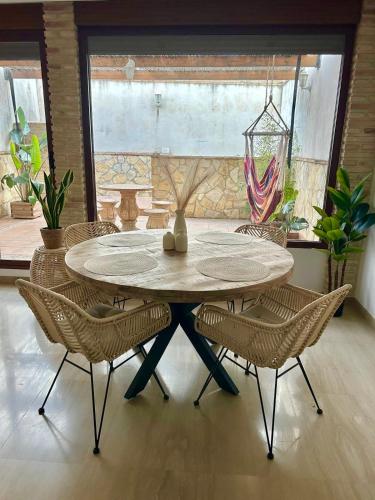 a dining room table with chairs and a vase on it at Casa con jacuzzi y piscina con vistas al castillo in Corbera de Alcira