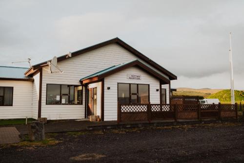 a small white building with a fence in front of it at Hótel Fljótshlíd in Hlíðarendi
