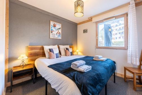une chambre avec un grand lit avec des serviettes dessus dans l'établissement Le Regency - à 5 min à pied des pistes, à Saint-Gervais-les-Bains