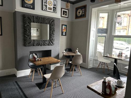 a restaurant with tables and chairs and a mirror at The Woodszz guest house in Whitby