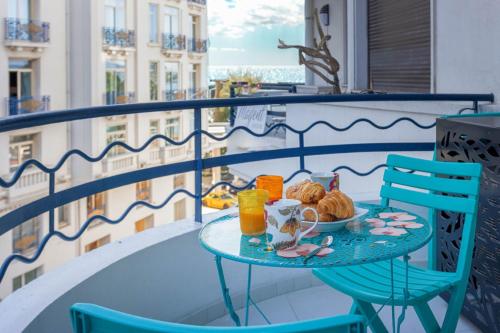 une table avec une assiette de nourriture sur un balcon dans l'établissement Palais Des Iles 2 by Halldis, à Cannes