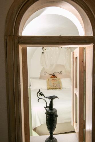 a bedroom with a bed through a glass doorway at Alexander's Suites in Oia