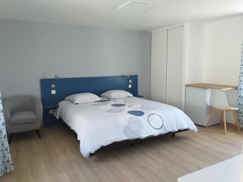 a bedroom with a blue and white bed and a desk at Maison de campagne occitanie in Compolibat