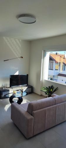 a living room with a couch and a large window at Tominettihome in Verbania